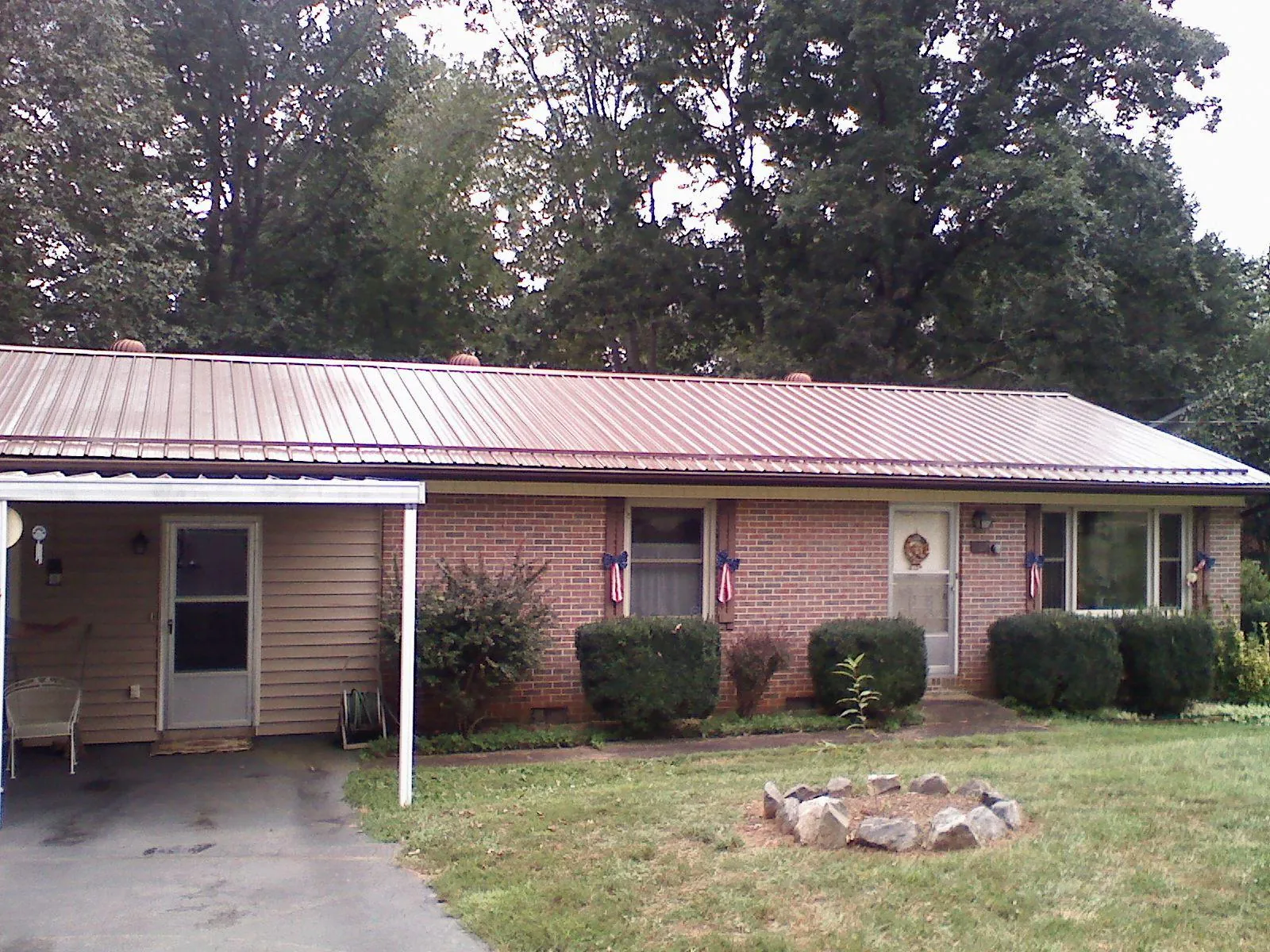 Bronze metal roof and carport on a brick ranch home — Roof Repair work by our crew in East Norwich